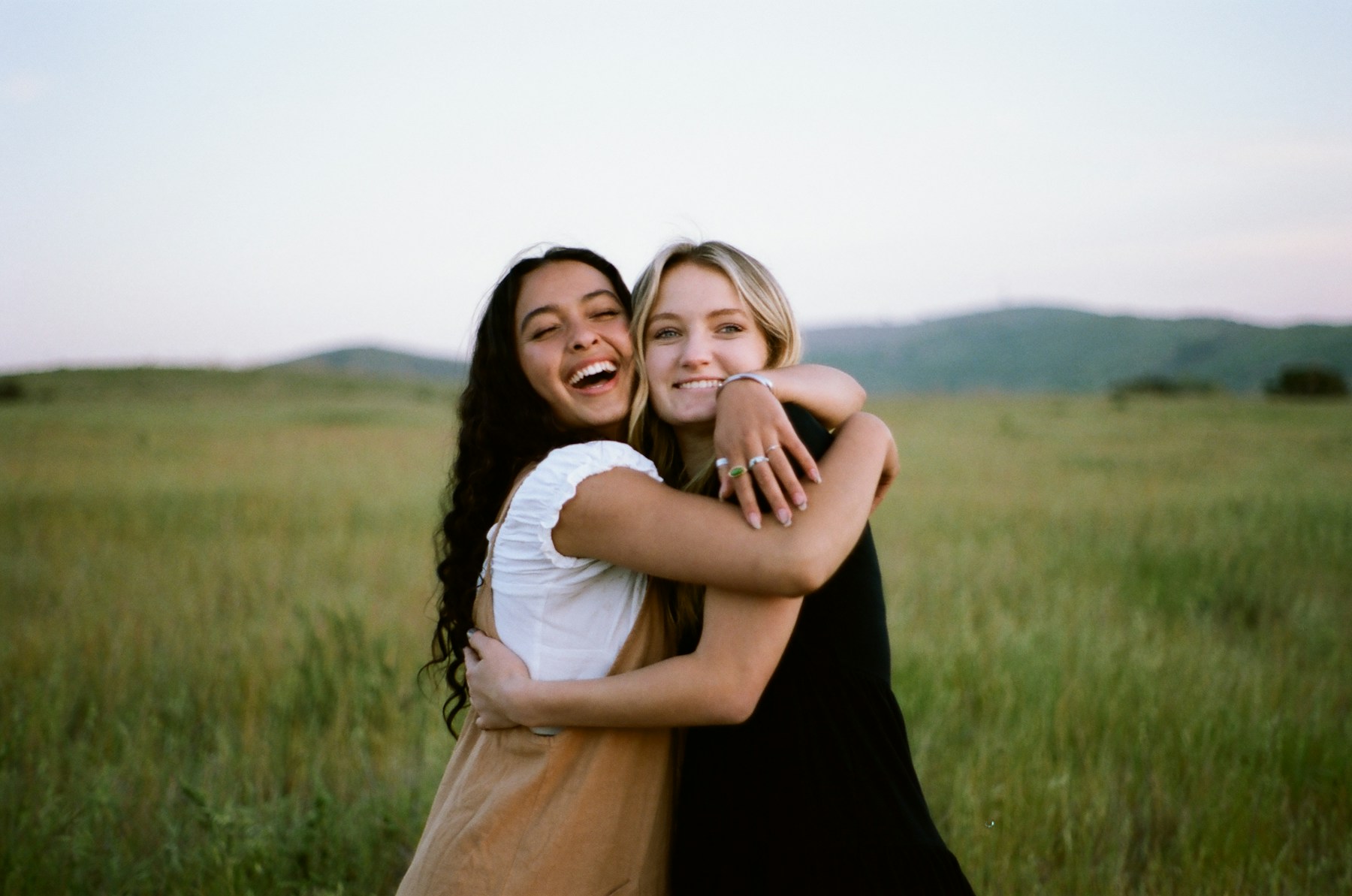 Two women sharing a joyful embrace outdoors